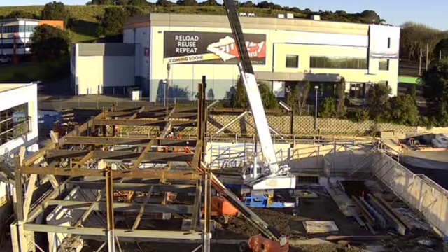 Looking down over timber formwork across the ground floor, with a mobile crane on site