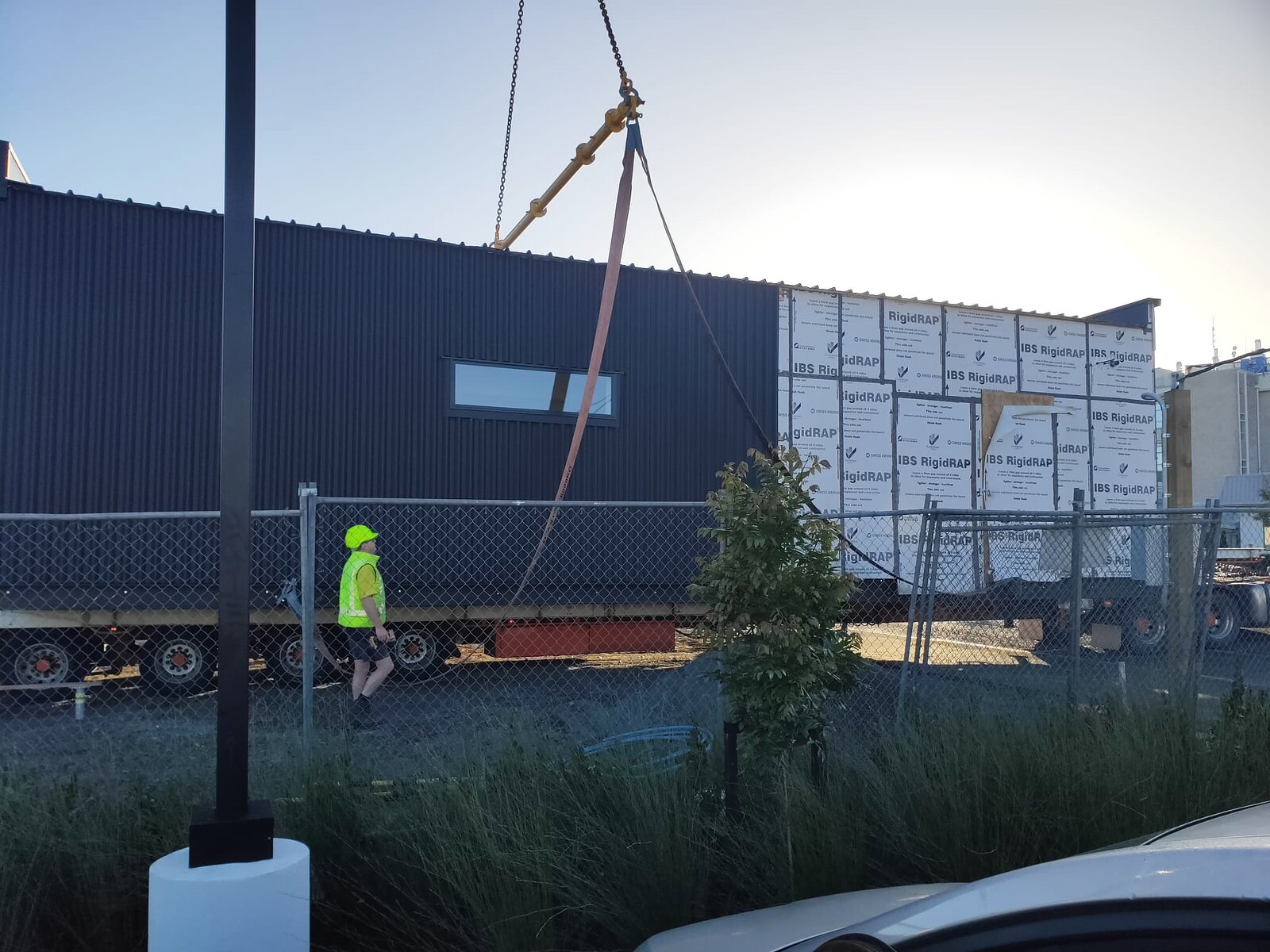 A completed clinic module arriving on a truck and being rigged for lifting