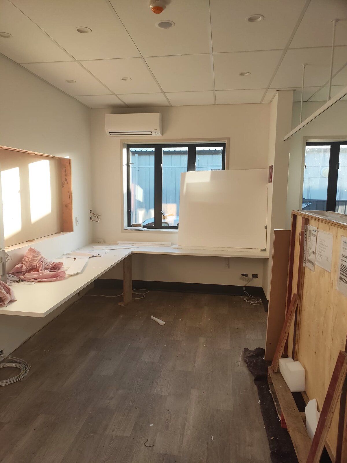 A clinic room with its bench joinery being installed and a hand basin fitted