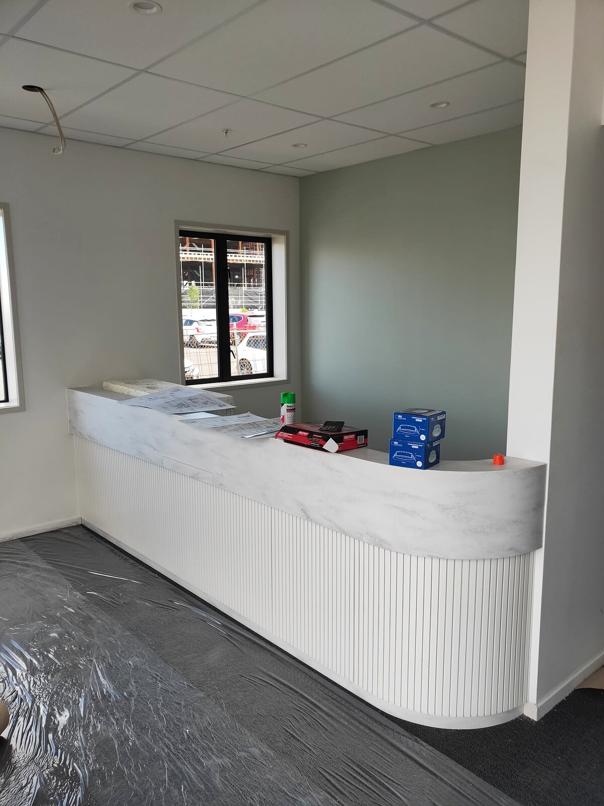 The reception counter with its fluted front and stone top, near the clinic entrance